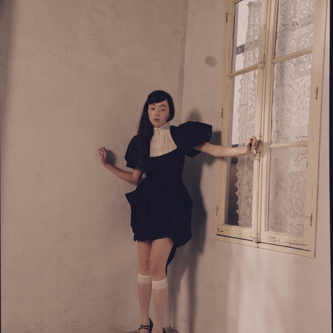 A black dress against a pale wall